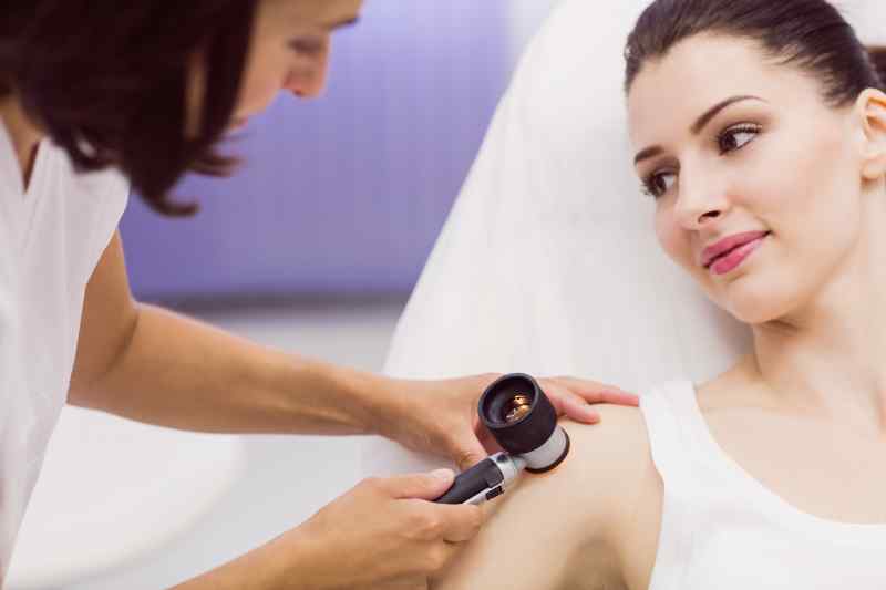 Dermatologist Examining Skin Patient With Dermatoscope