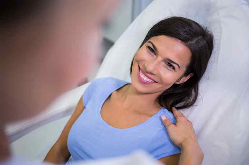 Female Patient Smiling While Talking Doctor